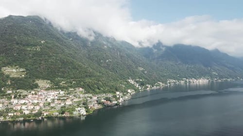 Drone footage panning across the shores of Lake Como in Italy. Clouds over the mountains and famous