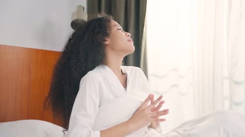 Woman Wakes Up and Stretches in Bed