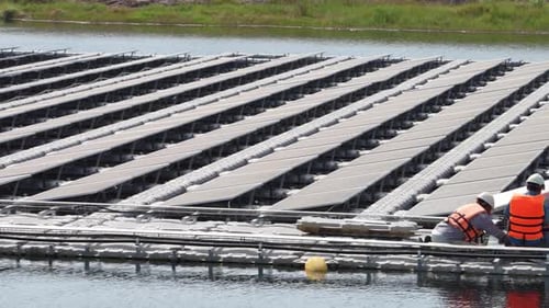 Schwimmendes Solarpanel auf dem Teich. Der Arbeiter wartet und überprüft schwimmende Photovoltaikmodule.