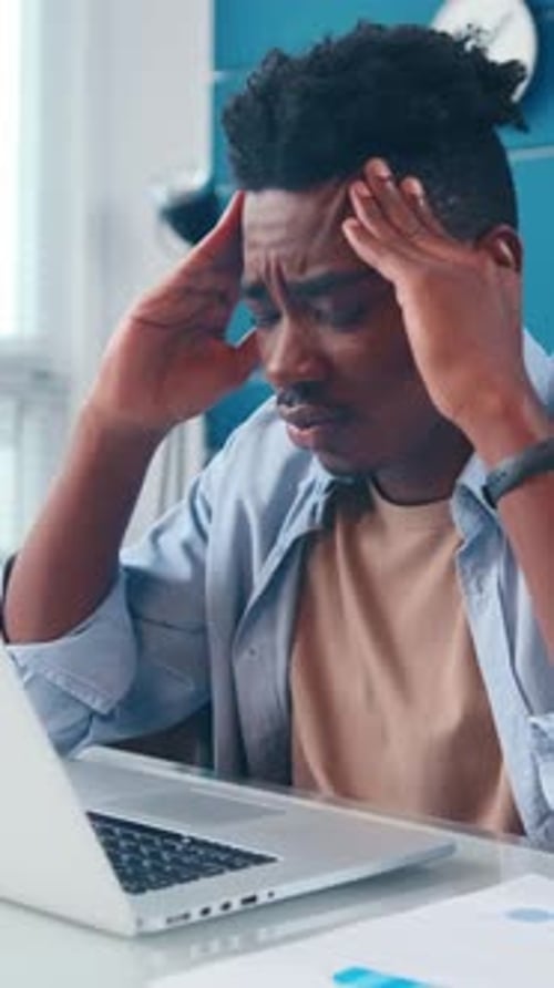 Stressed Young Man at Desk in an Office