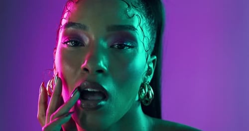 Face, makeup and woman with glow, neon and dermatology on purple studio background