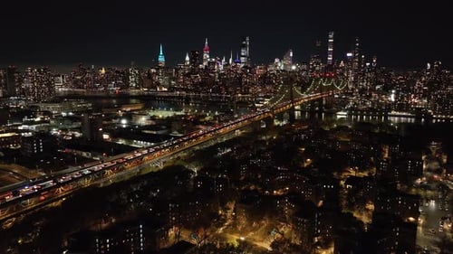 Aerial View Capturing Lively Movement of Vehicles on Queensboro Bridge Directing Towards Glowing