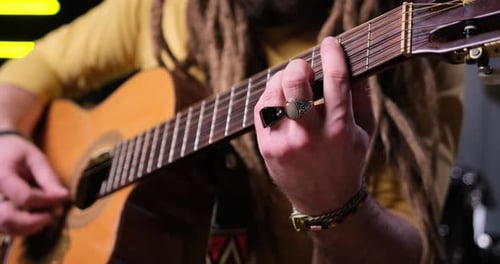 Guitarist Man Plays an Acoustic Guitar Closeup at Studio
