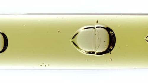 Golden Liquid Flowing Through Glass Tube Macro Shot