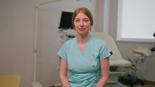 smiling doctor gynecologist sits in gynecological office near ultrasound machine and gynecological