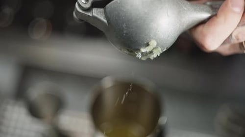 Nahaufnahmevideo in Zeitlupe, in dem eine Limette mit Eis in ein Glas gepresst wird