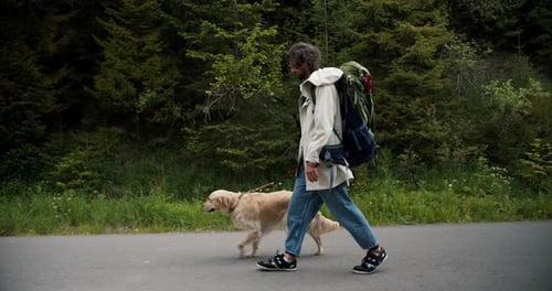 Man Walking Dog on Rural Road in Nature
