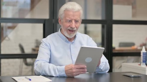 Old Businessman Celebrating Success on Tablet in Office