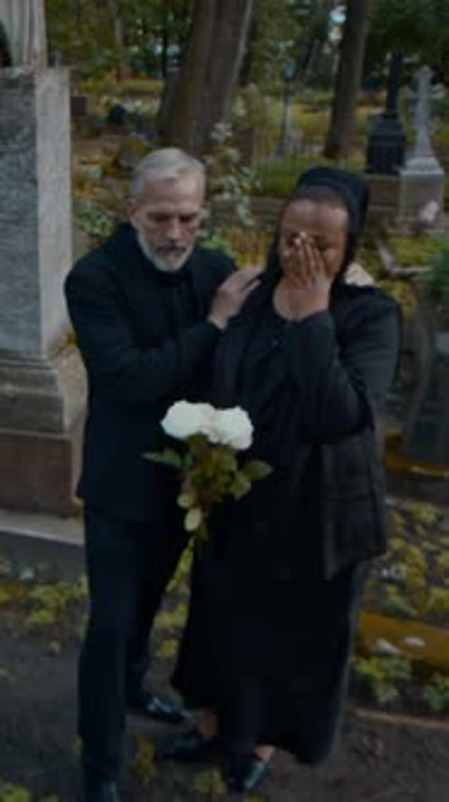 Weeping Wife Leaning on Shoulder of Husband Consoling Her in Cemetery