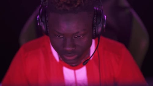 Concentrated Young Adult Gamer Wearing Headset