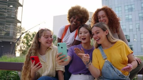 Friends Laughing at Phone in Urban Setting