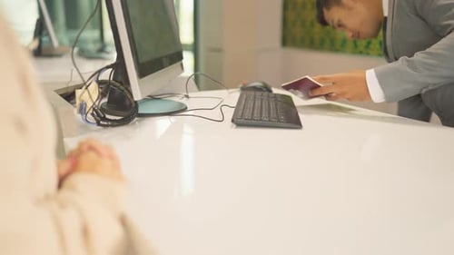 Airline staff explain about the ticket or Boarding Pass to customer at service counter in airport