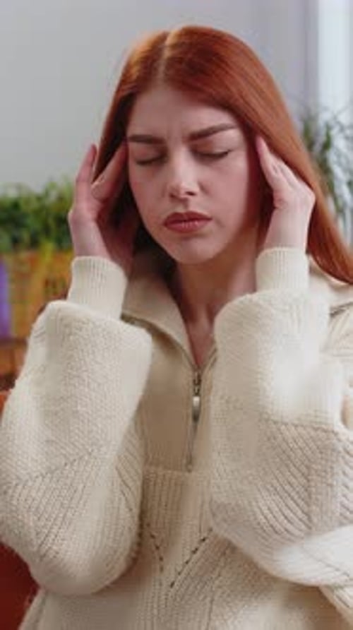 Woman Massaging Temples For Headache Relief Indoors