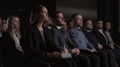 Audience Attending Business Conference or Presentation, Dark Setting