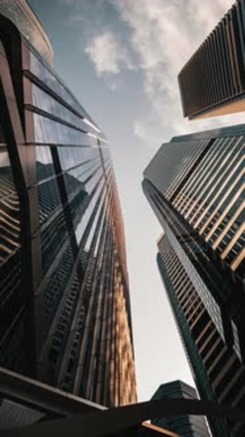 Time lapse of modern walls are made of glass and steel with reflections of blue sky.
