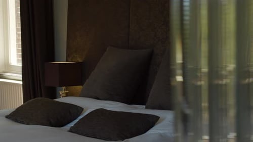 Dolly reveal of headrest on double bed in beautiful hotel room - close