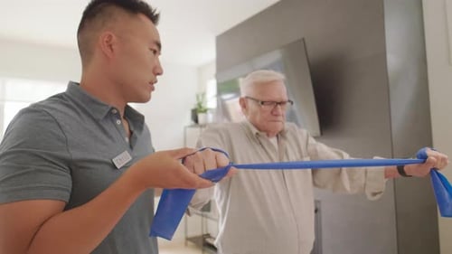 Man Assists Senior with Exercise Band in Modern Home