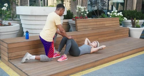 Woman Doing Situps with a Man Assisting