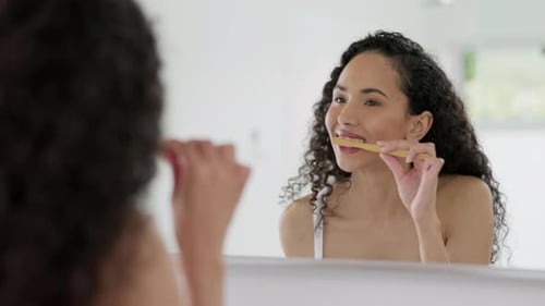 Woman Brushing Teeth in a Clean Bathroom