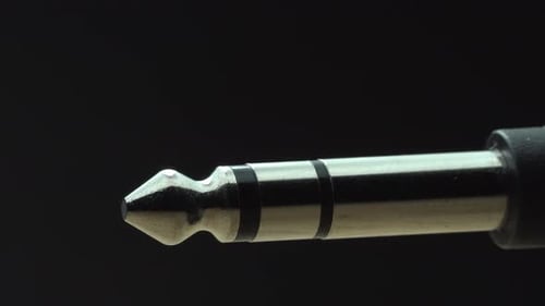 Light swipe across frame two time over extreme macro quarter inch electric guitar plug