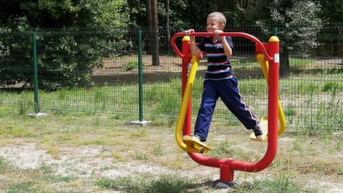 Child Boy Engaged on Sports Training Simulator at the Street in Slow Motion
