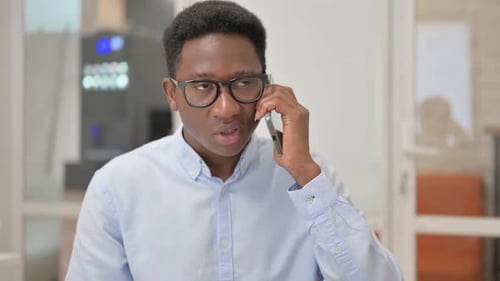 Young Adult Man Answers his Phone