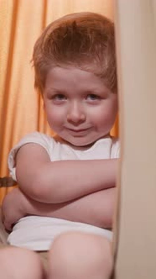 Embarrassed Boy Smiles and Looks in Camera Crossing Arms