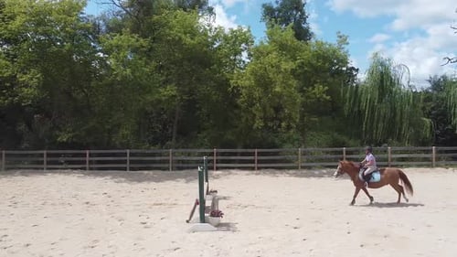 Woman Riding Horse in Rural Outdoor Riding Arena