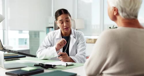 Doctor Consults With Senior Patient in Office