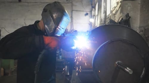 Worker in Protective Mask Welding Metal Construction at Industrial Production