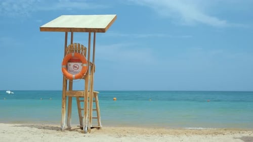 Empty Wooden Lifeguard Station on Sandy Beach on Ocean Shore in Summer