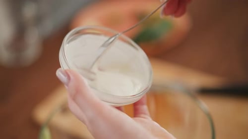 Close Up of Hand Scooping Salad Cream From Glass Container
