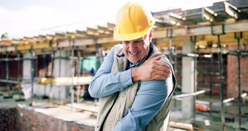 Construction, injury and mature man with shoulder pain, accident and muscle fatigue at building