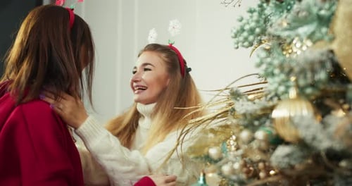 Women Decorating Christmas Tree with Love and Joy