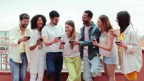 Friends Cheering with Red Wine on Urban Rooftop