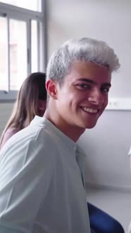Portrait of Young Man Sitting in Circle Next to His Schoolmates at Class Looking at Camera Smiling