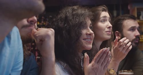 Girls and Guys Fans of Soccer Watching Match Together in Evening in Pub and Worry for Their Favorite