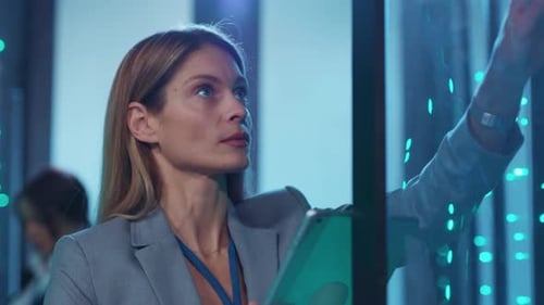 Woman Working in a Server Room with Tablet