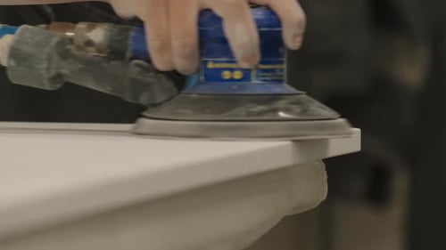 Close-up of master polishing wooden board