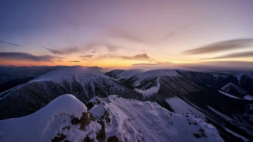 Winter Mountain Landscape Timelapse During Blue Hour with Soft Wispy Clouds Moving Over Peaks