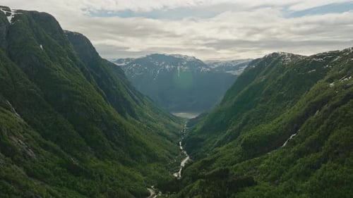 Drone Fly Through Lush Valley with Waterfalls of Slope, River to Lake and Snow Capped Mountains