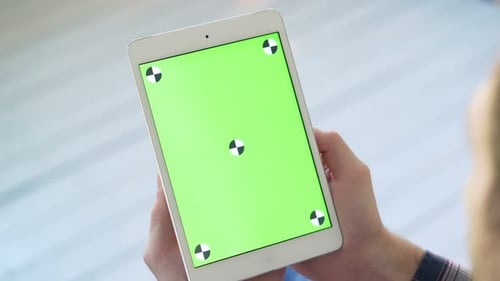 Using Tablet Pc With Green Screen. A Man Holds A Smart Tablet With A Greenscreen For Your Own Cus...