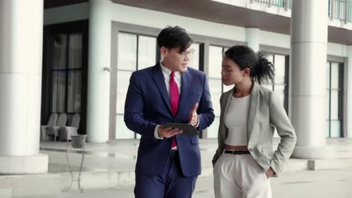 Business Colleagues Discussing Technology Outside Office Building