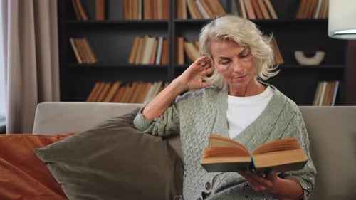 Woman Reading a Book on the Couch at Home