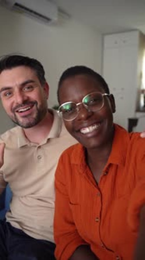 Happy Couple Smiles and Waves in Home Setting