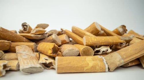 Primer plano de colillas de cigarrillos en blanco