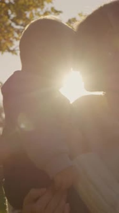Vertical video Mother and child enjoy a sunset stroll in park filled with joy