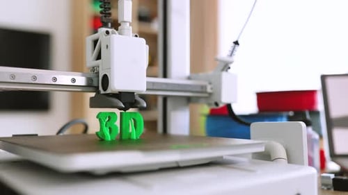 3D-Drucker, der grüne Buchstaben erstellt