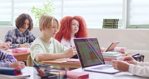 Attentive School Age Students Noting Lecture on Digital Tablets During Lesson Teacher with Wireless