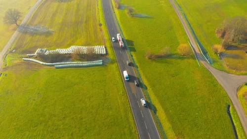 drone flight over open country road with some traffic